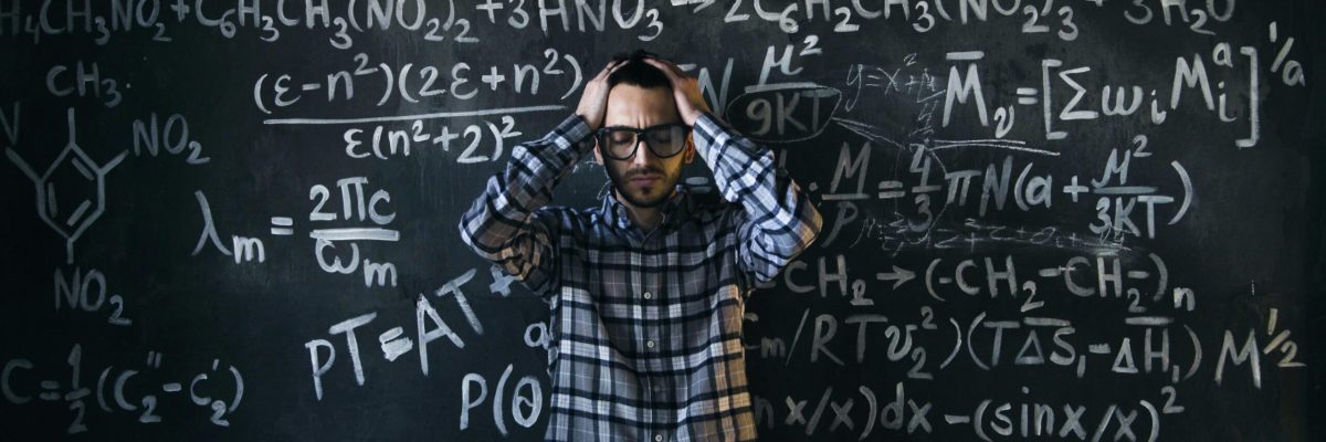 Man standing in front of a chalkboard covered in complex equations